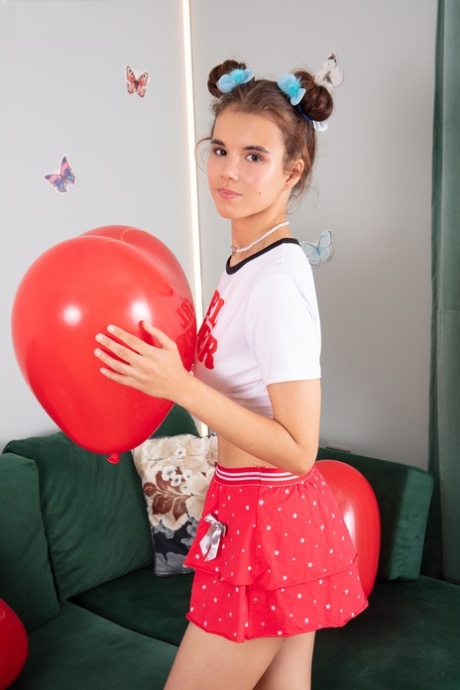 Adorable teen Midia holds a couple of balloons before getting naked