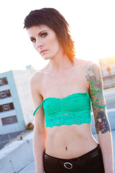 Skinny alt babe with tattooed body exposing tiny tits outdoors on rooftop