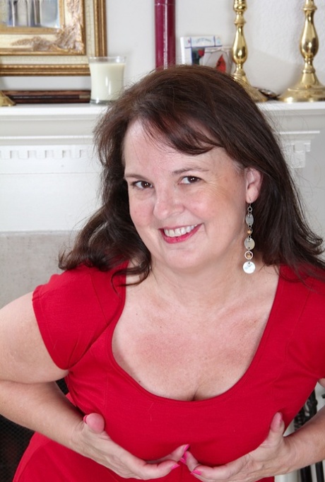 Older amateur Felicia Mcdonald doffs a red dress before parting her pussy lips
