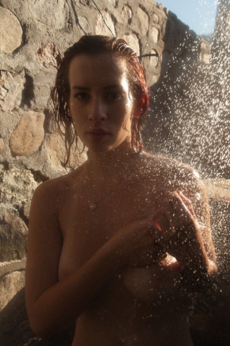Busty babe Orli Krowan loses her sheer purple dress outdoors & takes a shower