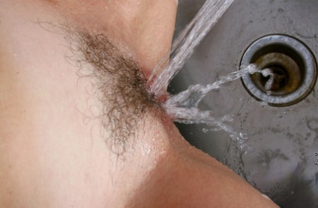 Amateur housewife Katie washes her tits & hairy pussy in the kitchen sink