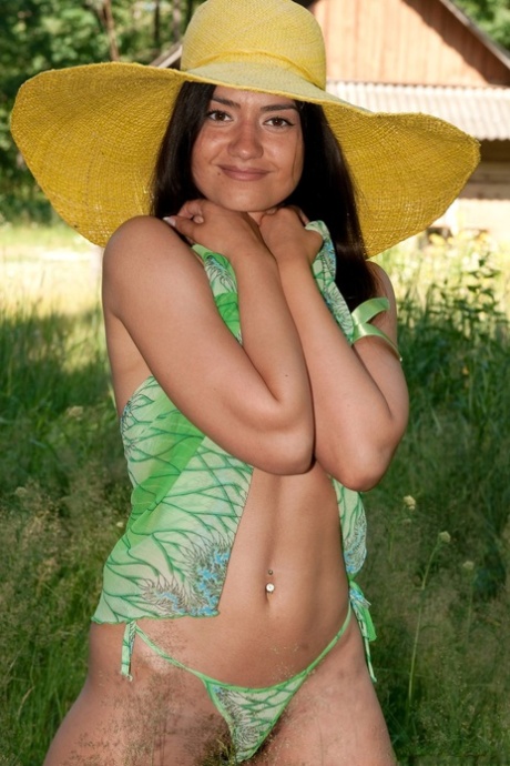 Slender brunette Julie shows her natural tits and hairy vagina outdoors