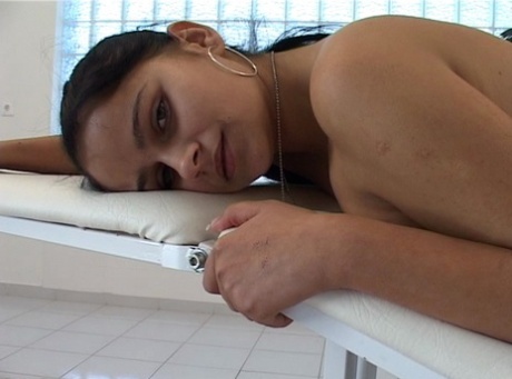 Curvy blonde Szilvia Eiler bends over for an anal fingering on a massage table