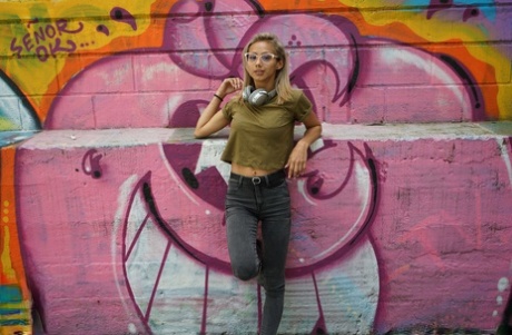 Veronica Leal posing all over her hood in green shirt and tight jeans