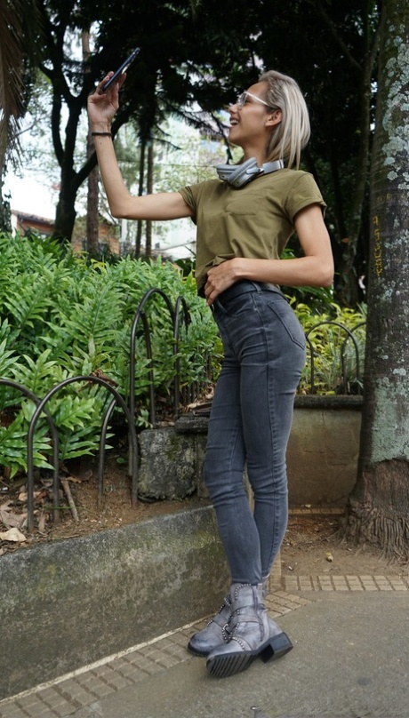Veronica Leal posing all over her hood in green shirt and tight jeans