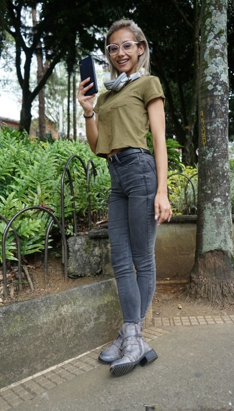 Veronica Leal posing all over her hood in green shirt and tight jeans