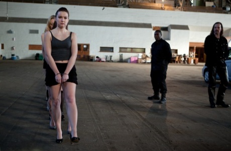 Lined up damsels in handcuffs getting stripped by their male BDSM handlers