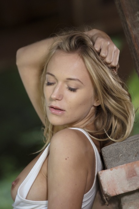 Sweet blonde Aislin strips outdoors, squats down and plays with her clit