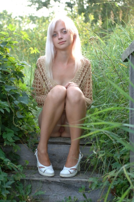 Petite teen Lesi A shows her tiny tits and her lickable shaved pussy outdoors