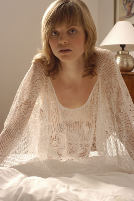 Sexy blonde Margo A posing in her see-through white lingerie on the bed