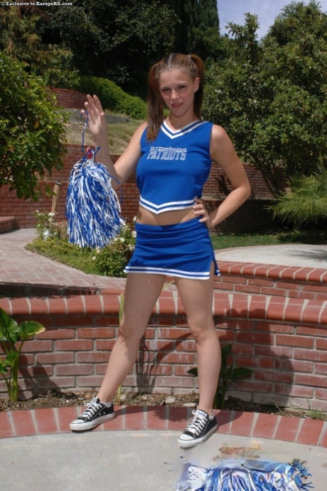 Petite cheerleader Holly Webster teasing with her juicy natural tits outdoors