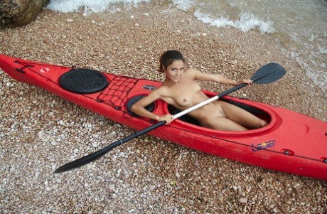 Pretty babe Sati shows her tight trimmed pussy while kayaking all nude