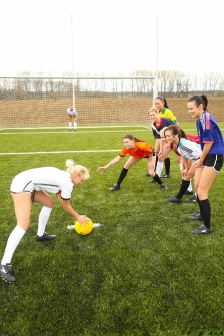Kinky soccer babes strip each other and flaunt their titties on a soccer pitch