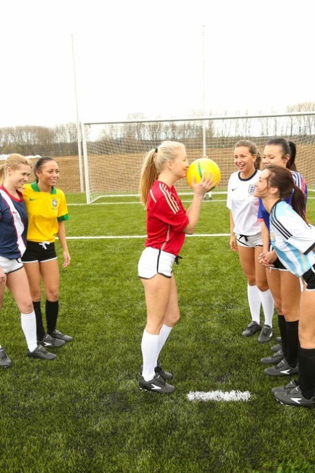 Kinky soccer babes strip each other and flaunt their titties on a soccer pitch