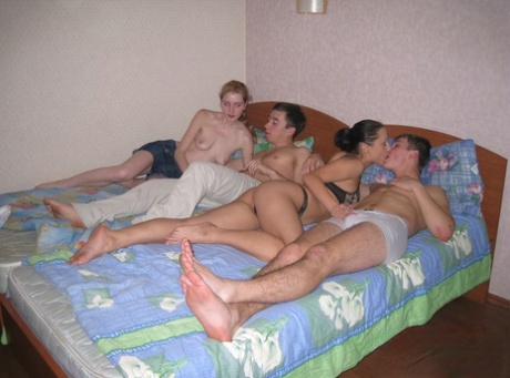 Horny teens Karina and Misha undress and share a two stiff pricks on a bed