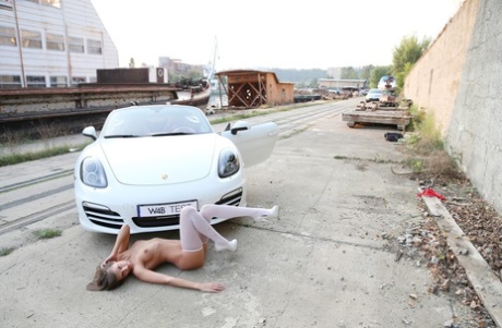 Adorable model with long legs Maria poses in stockings in a car
