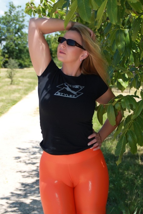 Curvy MILF in orange tights Desyra Noir shows her juicy bum outdoors