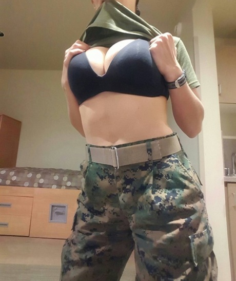 Hot babe with big juggs doffs her military uniform and poses in a solo
