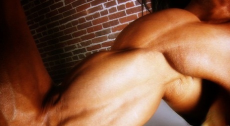 Bodybuilder with tanned body Marina Lopez shows her fakes and poses