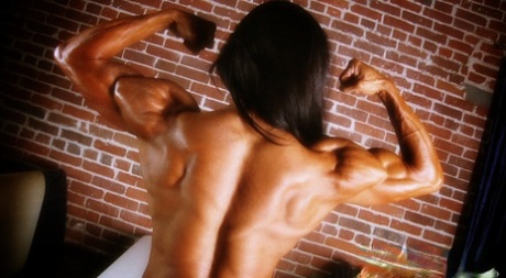 Bodybuilder with tanned body Marina Lopez shows her fakes and poses