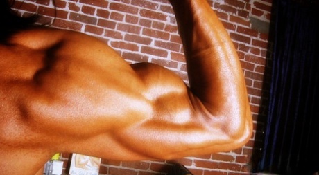 Bodybuilder with tanned body Marina Lopez shows her fakes and poses