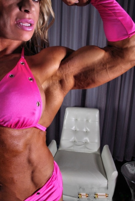 Sexy bodybuilder Debi Laszewski shows her tanned muscles in her pink bikini