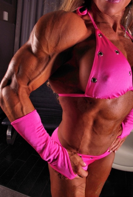 Sexy bodybuilder Debi Laszewski shows her tanned muscles in her pink bikini