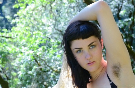 Adorable amateur babe Myre strips in an orchard and shows her hairy armpits