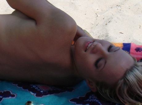 Teenage hottie Cari displays her hot naked body while sunbathing on the beach