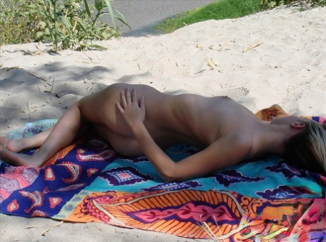 Teenage hottie Cari displays her hot naked body while sunbathing on the beach