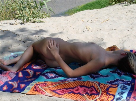 Teenage hottie Cari displays her hot naked body while sunbathing on the beach