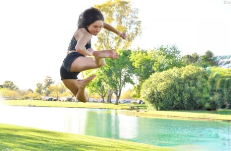 Teenage hottie in sexy outfit Zoe doing exercise outdoors by the water