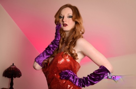 Glamorous ginger Zara Du Rose posing in her long red dress & heels