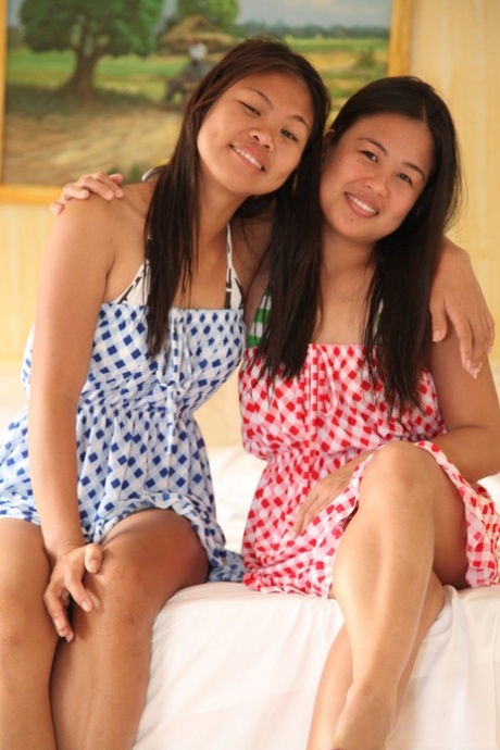 Asian babe Anne Agustin and her lesbian friend undress and pose on a bed