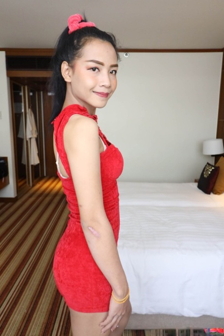 Petite Asian shemale in a red dress flashes her undies before sucking a dick