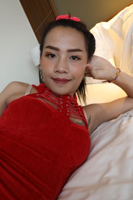Petite Asian shemale in a red dress flashes her undies before sucking a dick