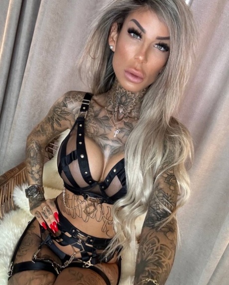 Big-breasted glamour babe shows off her stunning tattoos in strappy lingerie