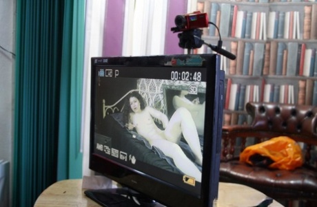 Curly-haired beauty poses nude & in a short dress in a behind the scenes solo
