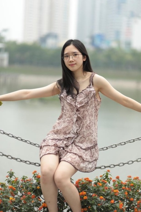 Good-looking Asian sexpot teases in a sexy short dress outdoors