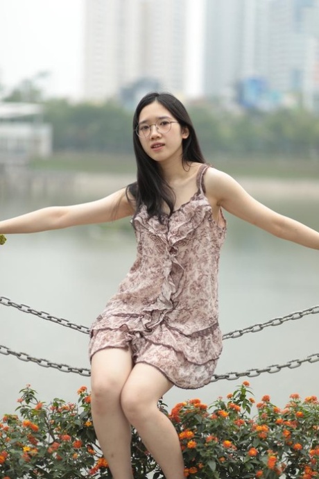 Good-looking Asian sexpot teases in a sexy short dress outdoors