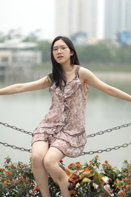 Good-looking Asian sexpot teases in a sexy short dress outdoors
