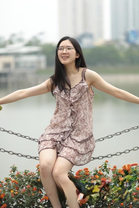 Good-looking Asian sexpot teases in a sexy short dress outdoors