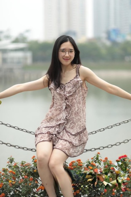Good-looking Asian sexpot teases in a sexy short dress outdoors