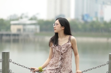 Good-looking Asian sexpot teases in a sexy short dress outdoors