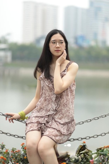 Good-looking Asian sexpot teases in a sexy short dress outdoors