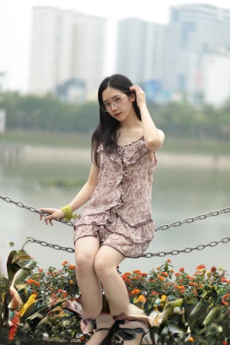 Good-looking Asian sexpot teases in a sexy short dress outdoors