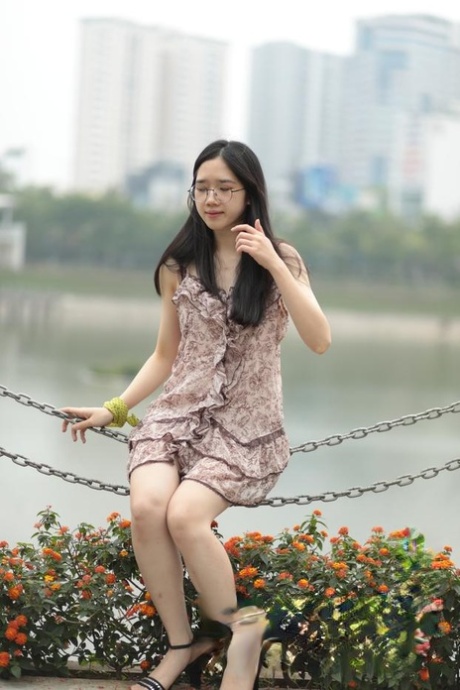 Good-looking Asian sexpot teases in a sexy short dress outdoors