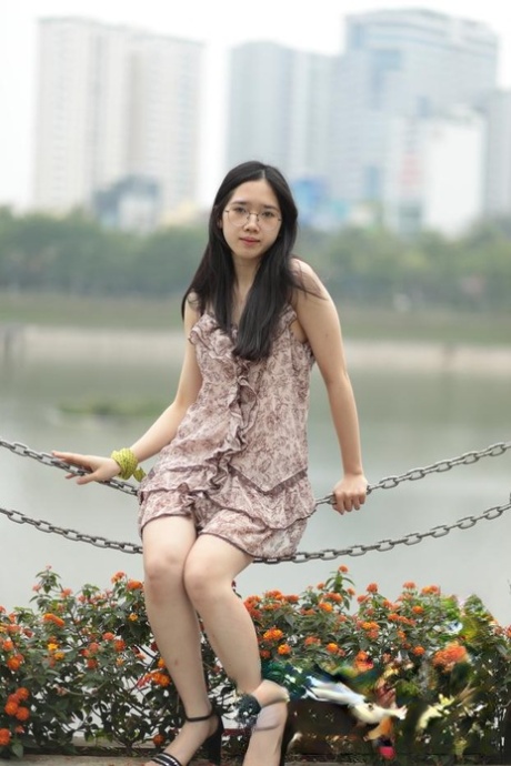 Good-looking Asian sexpot teases in a sexy short dress outdoors