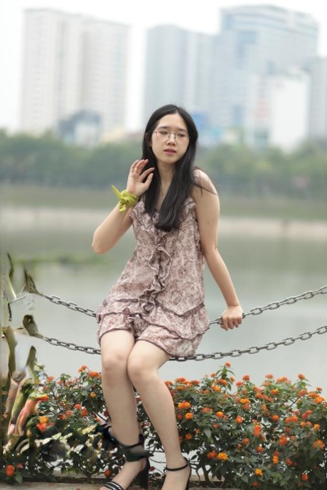 Good-looking Asian sexpot teases in a sexy short dress outdoors