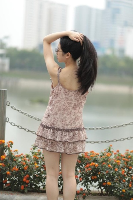 Good-looking Asian sexpot teases in a sexy short dress outdoors